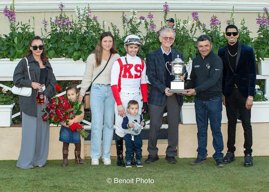 Program Trading’s connections receiving the Hollywood Derby Trophy: Flavien Prat in Kravich Stables’ silks with his wife and children, Del Mar representative presenting to Chad Brown’s assistant trainer, Jose Hernandez (right). (Benoit Photo)