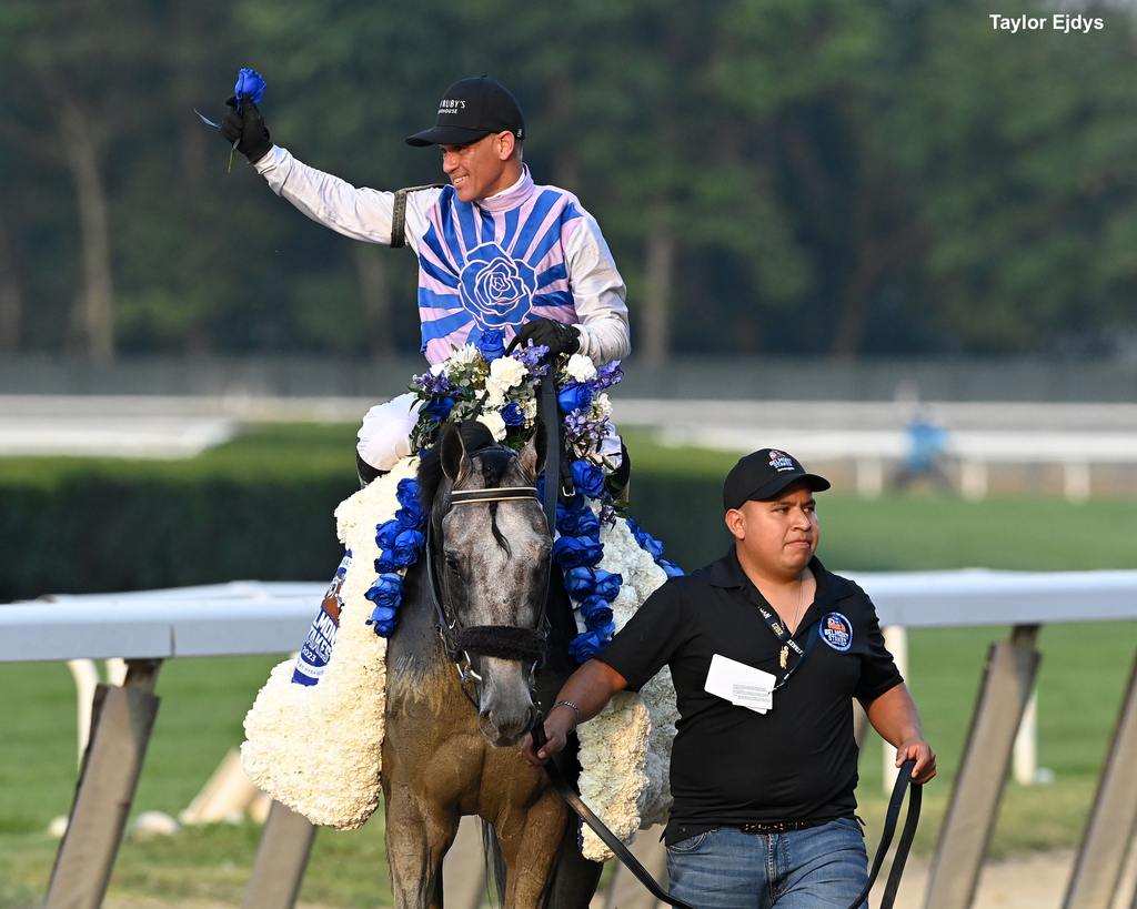 Castellano’s raises the blue rose after his historic victory in the Travers aboard Arcangelo. (Taylor Ejdys)