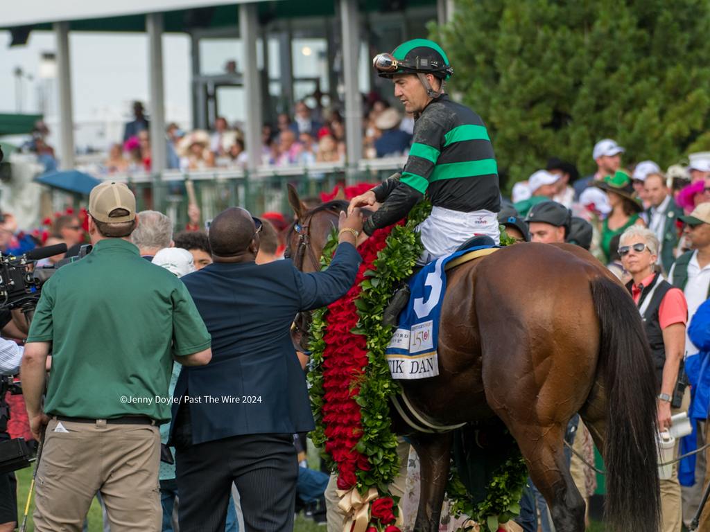Brian Hernandez and Mystic Dan carry the garland of roses. (Jenny Doyle/Past The Wire)